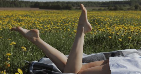 Legs of young woman against meadow. Outdoor lifestyle portraitの写真素材