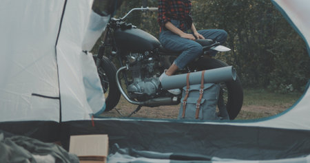 Young tourist on vacation in forest. Hiker girl biker sitting on motorcycleの写真素材