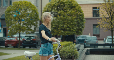 Young pretty woman riding bicycle in city