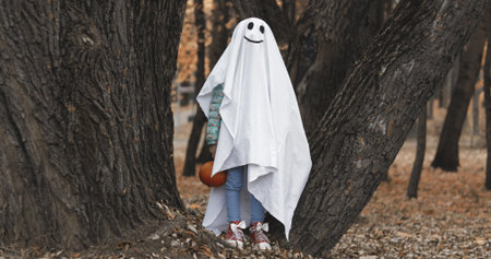 Little girl in a costume ghost . Halloween celebration holiday. Funny smiling grimaceの写真素材