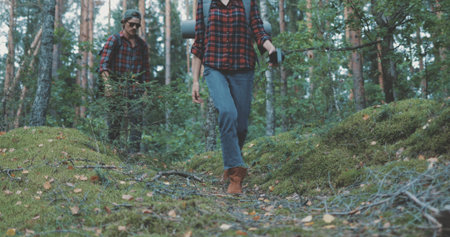 Young man and woman hiking in forest. Hiker camping in woods. Tourist couple walking by stream.の写真素材