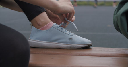 Closeup human hands tying laces on sneakers. Urban city lifestyle sport outdoors conceptの写真素材