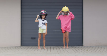 two sisters in firefighter helmetsの写真素材