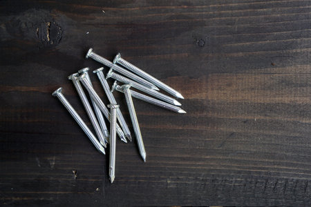 Metal nails on wooden background with copy space for text. Top view.の写真素材
