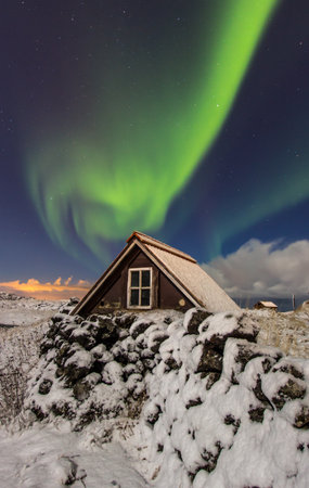 Northern lights above old cottage just outside the city of Reykjavik, Icelandのeditorial素材