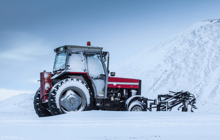 Old red tractor outside during winter time.の写真素材