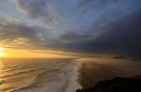 Sunset at the south coast of Iceland. Fantastic view over the foggy black sand at the beach