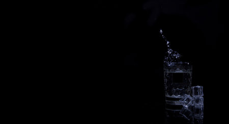 Ice cube is falling into a drinkの写真素材