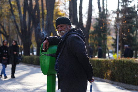 Rajai park, Isfahan, Isfahan province, Iran- 12/16/2017: retired guy standing in a park. old men usually gather in Rajai park to hang out in the eveningのeditorial素材