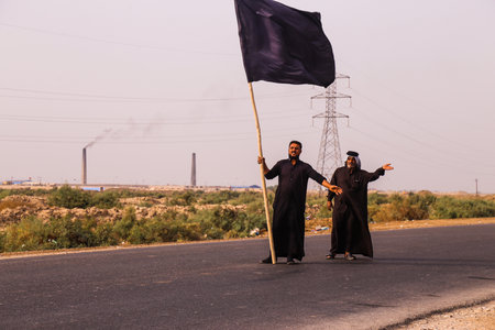 Najaf, Iraq - 11/3/2017 : Iraqi people holding a flag, inviting pilgrims on the road into their...
