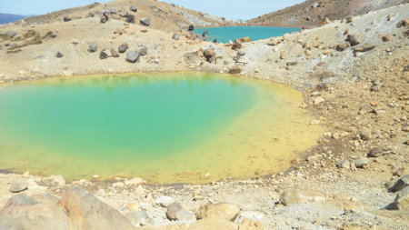 Turquoise and yellow colors of the vulcanic crater lakes on top of the mountains. Stony, rocky landscape on the Tongariro Alpine Crossing Tour.の写真素材