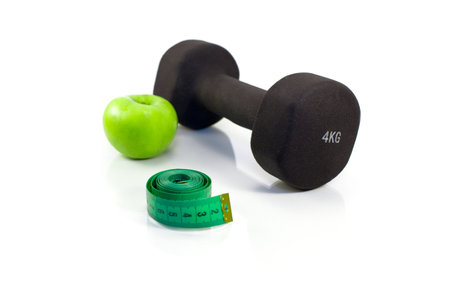 Dumbbell, green apple and measuring tape on a white background. Isolatedの写真素材