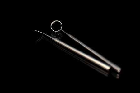Dental mirror and dental sonde. Image isolated on black background.の写真素材