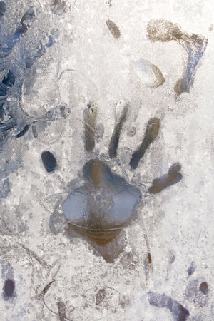 handprint on the frozen ice window. Close upの写真素材