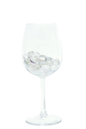 Sparkling stones in a wine glass isolated on whiteの写真素材