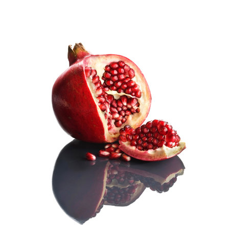 Pomegranate opened up on reflective white surfaceの写真素材