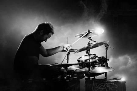 Drummer playing the drums with smoke and powder in the background