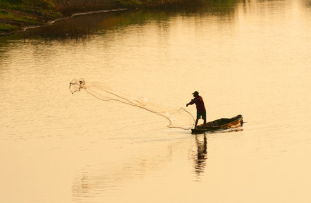 A man throw fishing net in evening, Thailandの写真素材