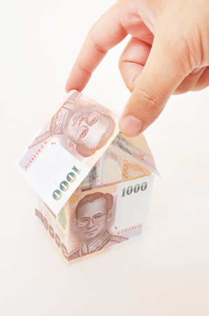 Hand putting money to build homesの写真素材