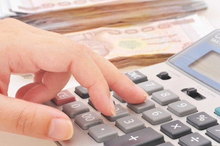 woman s hands with a calculator and thai baht on a background の写真素材