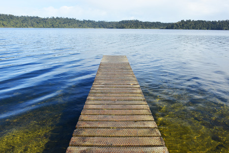 wooden bridge leading out onto the lakeの写真素材