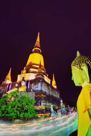 People hold candle light walking past the front of pagoda in Wian Tian ceremony. Wesak or Vesak also known as Buddha Purnima and Buddha Day.Part of the ruin of Wat Yai Chai Mongkol in Ayutthaya.のeditorial素材