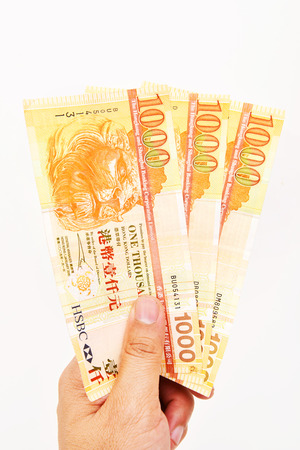 Hand with three of 1000 HongKong Dollars banknoteのeditorial素材