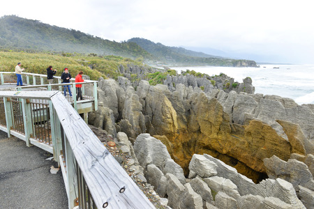 PUNAKAIKI, NEW ZEALAND, NOVEMBER 14, 2014: Tourists photograph themselves while the main blowhole is in action at the Pancake Rocks, Punakaiki, West Coast, South Island, New Zealandのeditorial素材
