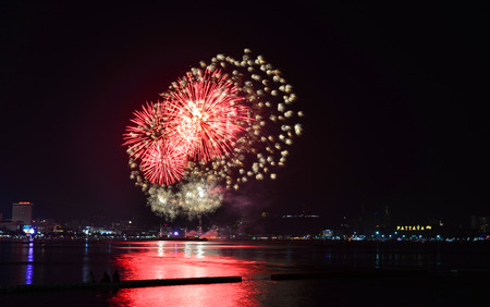 Multicolor fireworks night scene, closeup with pattaya cityscape sea beach view, Thailand.