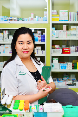Bangkok,Thailand - JAN 9:Asian pharmacist chemist woman standing in pharmacy drugstore on JAN 9,2016 in Bangkok,Thailand.Over 12,123 pharmacy drugstore in Thailand.のeditorial素材