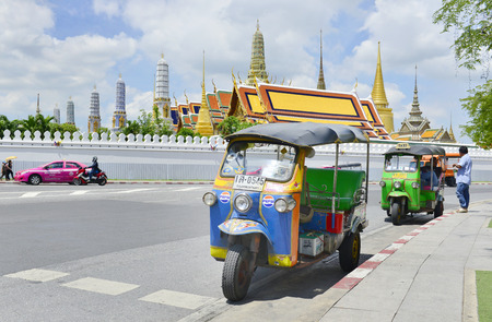 BANGKOK, THAILAND - JULY 27 : Tricycle taxi of Thailand on street and background of Wat Phra Kaew ( the Temple of the Emerald Buddha) on July 27 , 2016. Here is destinations of landmarks travelerのeditorial素材