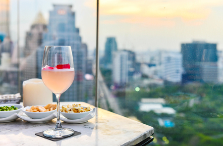 Cocktail glasses in Restaurant couch bar with view of Bangkok Cityscapeの写真素材