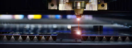 Industrial laser cut machine while cutting the sheet metal with the sparking light.