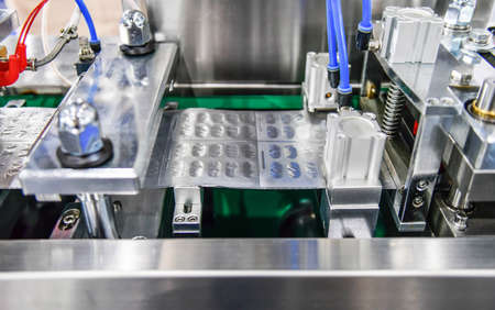 Blue capsule medicine pill production line, Industrial pharmaceutical concept.