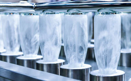 Cleaning bottles glass bottles for beverage product in process by hot water in automatic machine at manufacturingの写真素材
