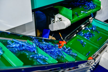 Blue Plastic bottles in production line at manufacturing PET perform, before bottles blowing in...