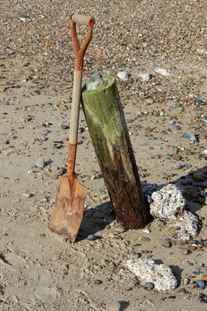 Old wooden handled spade on a beachの写真素材