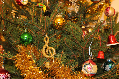 Real natural Christmas tree with decorations including baubles, balls, bells, tinsel, lights and even a toucan.の写真素材