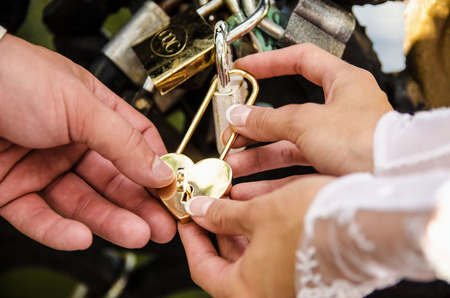 the bride and groom mesh grate gold lock on the bridge.の写真素材