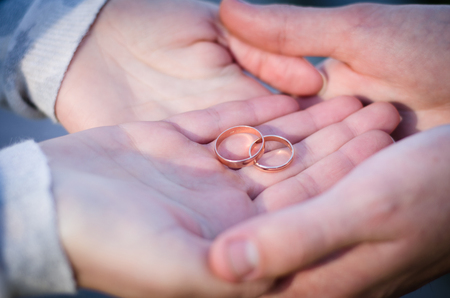 gold rings in the hands of the bride and groomの写真素材