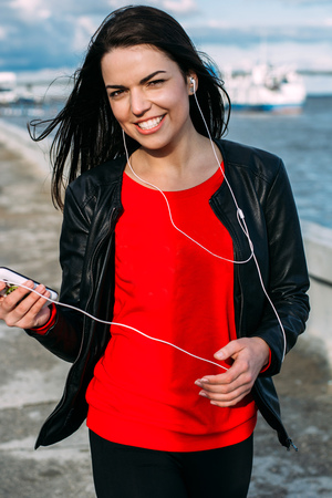 beautiful woman listening to music with headphones in the streetの写真素材