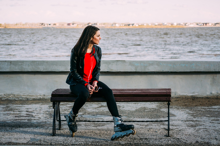 beautiful woman listening to music on the river bank