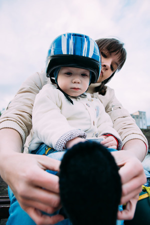 woman taking care of a child by helping him get dressedの写真素材