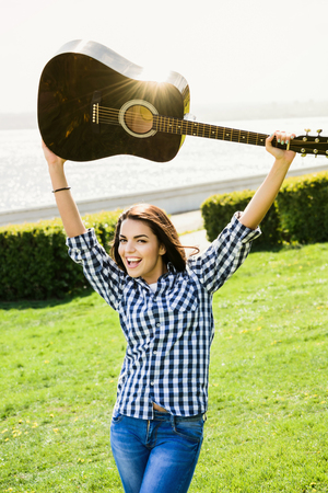 beautiful girl posing near a black guitarの写真素材
