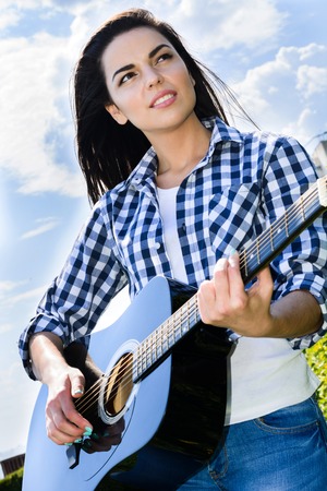 beautiful girl posing near a black guitar