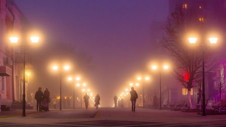 Evening cityscape with people going down the streetの写真素材