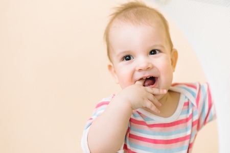 happy kid stuck his fingers in his mouthの写真素材