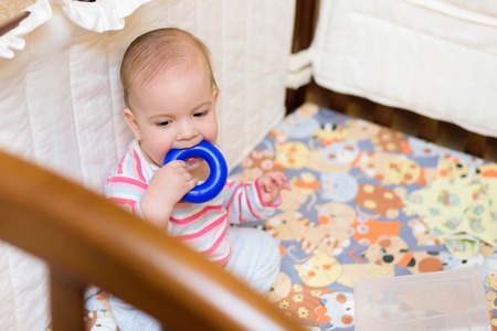 little boy playing with a toy in the cribの写真素材