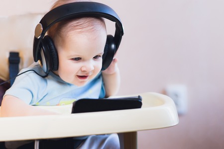 child listening to music on headphones at homeの写真素材