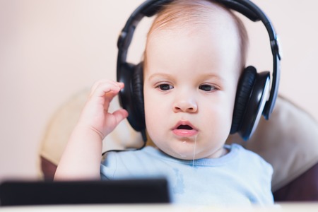 child listening to music on headphones at homeの写真素材